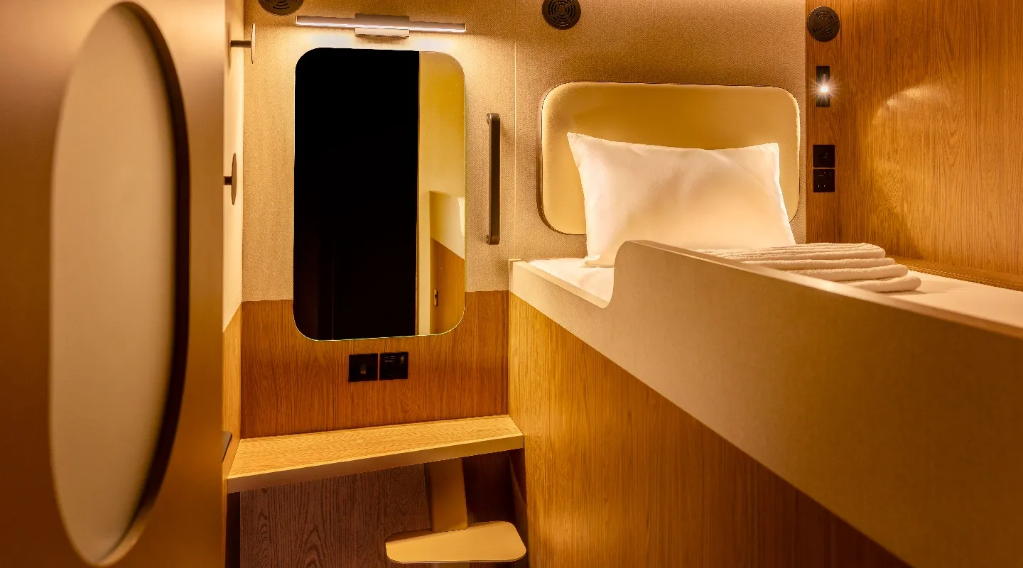 A cosy Kabannas single bed upper Cabin in warm lighting