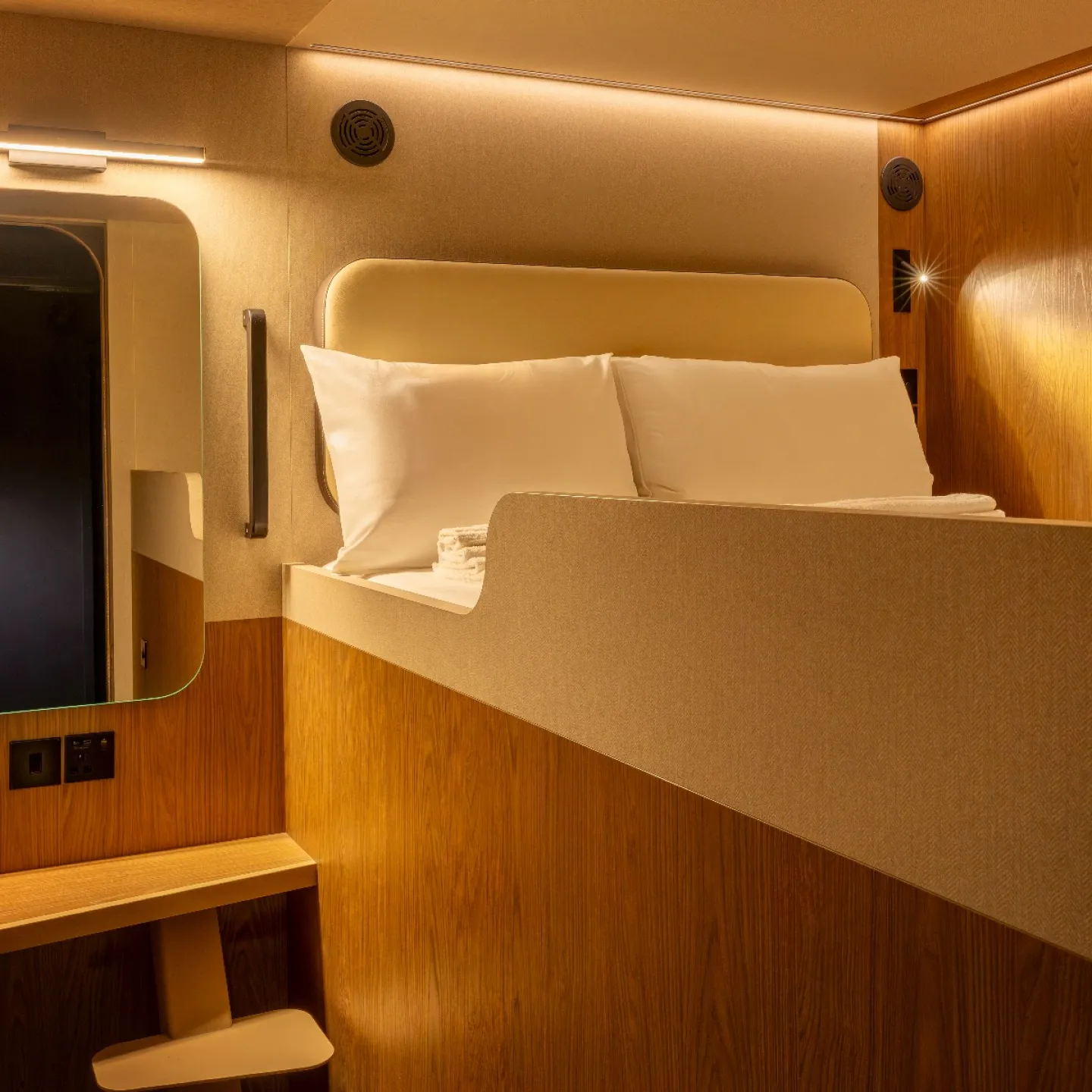 A Kabannas Cabin room with double bed, clean white sheets and wood paneling 