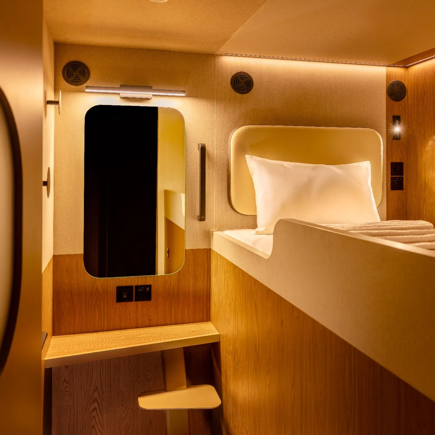 A Kabannas Cabin upper room with single bed, clean white sheets and wood paneling 